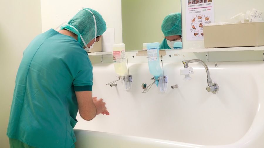 L'hygiène des mains est un geste barrière du quotidien pour les professionnels de santé comme ce chirurgien avant d'entrer au bloc opératoire.