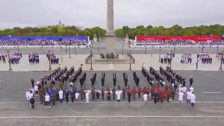 Les soignants ont été intégrés à la cérémonie du 14 juillet, place de la Concorde à Paris, et ont déplié le drapeau français avec les militaires français. (Groupement hospitalier Nord-Dauphiné)